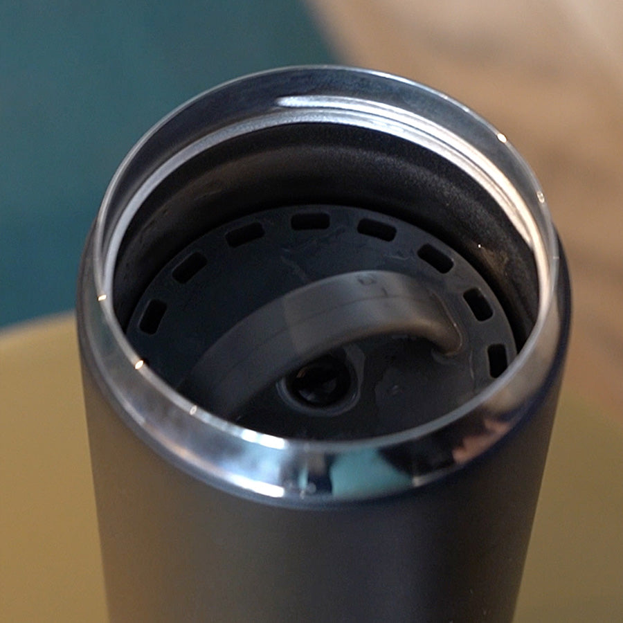 Close-up of the inside of a black thermos with a metal rim.